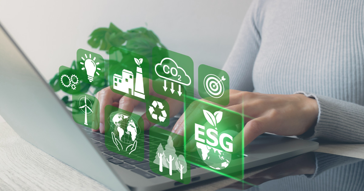 Pessoa usando um laptop com ícones digitais relacionados a ESG (Environmental, Social, and Governance) sobrepostos na imagem. Ícones incluem temas como energia renovável, emissão de CO₂, reciclagem, metas e sustentabilidade ambiental, empresa, stanford, biodiversidade
