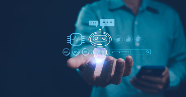 Imagem conceitual de inteligência artificial mostrando uma mão humana segurando hologramas digitais que representam um robô com ícone de IA, gráficos de progresso e uma barra de comando. Ao fundo, uma pessoa desfocada segura um celular, simbolizando a integração da IA na tecnologia móvel e nas interações digitais, agentes de ia, agente