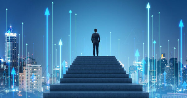Imagem conceitual de um homem de terno em pé no topo de uma escadaria, de costas, olhando para um céu azul-escuro com várias setas luminosas apontando para cima. A imagem transmite uma sensação de crescimento, progresso e ambição, simbolizando o sucesso e o avanço em direção ao futuro. Ao fundo, vê-se uma silhueta de edifícios, reforçando o ambiente urbano e corporativo, liderança