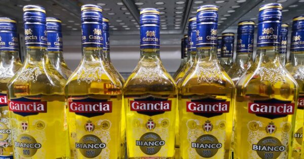 Garrafas da tradicional bebida Gancia Bianco, alinhadas em uma prateleira com rótulos amarelos e detalhes em azul, produto icônico do portfólio do Grupo Cepas, que investe em inovação tecnológica e modernização de sua operação na América do Sul.
