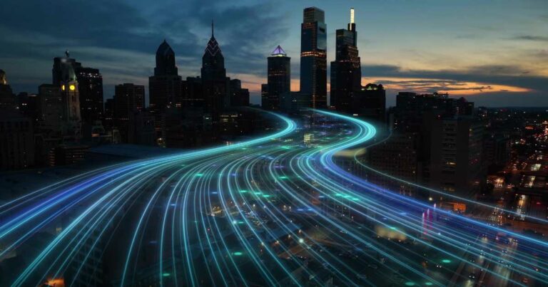 Imagem de uma cidade ao entardecer, com arranha-céus iluminados ao fundo e trilhas luminosas em tons de azul e verde sobrepostas digitalmente, simbolizando fluxos de dados ou conectividade. A cena representa o conceito de transformação digital em ambientes urbanos (cidades inteligentes, canais)