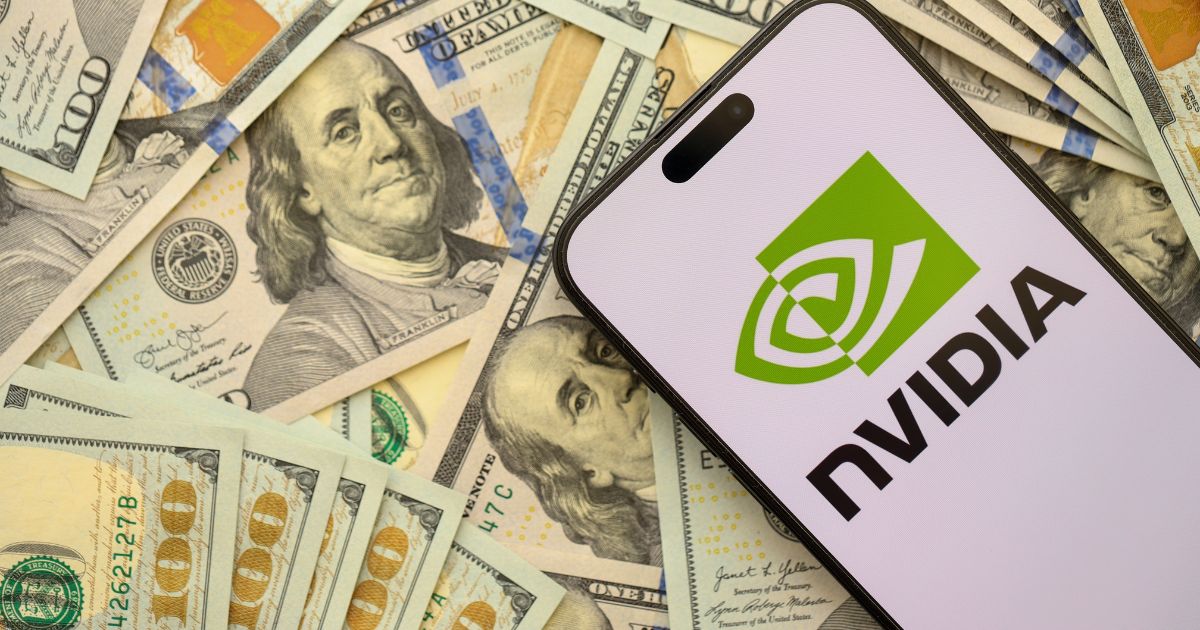 Um smartphone exibe o logotipo da NVIDIA e está posicionado sobre uma pilha de notas de 100 dólares americanos.
