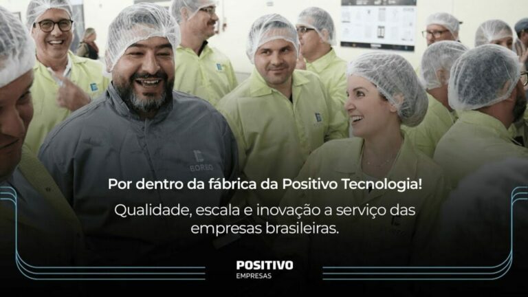 Grupo de pessoas sorridentes na fábrica da Positivo Tecnologia, destacando o ambiente de inovação, qualidade e crescimento da empresa.