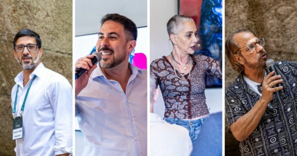 A imagem está dividida em quatro seções verticais, mostrando quatro pessoas diferentes em um ambiente de evento ou apresentação. A primeira pessoa, à esquerda, veste uma camisa branca e um crachá pendurado no pescoço, com fundo de parede texturizada. A segunda pessoa segura um microfone e veste uma camisa clara, com um fundo que parece ser uma tela de apresentação. A terceira pessoa usa uma blusa estampada de manga longa e colares, com um fundo que inclui uma imagem colorida emoldurada. A quarta pessoa, à direita, também segura um microfone e veste uma camisa com padrão geométrico, com um fundo semelhante ao da primeira seção. (filosofia)